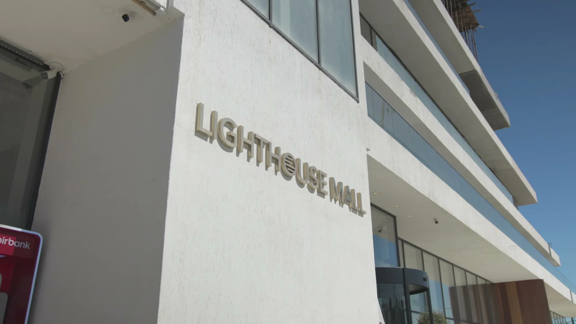 Буквы LIGHTHOUSE MALL на белой стене у входа